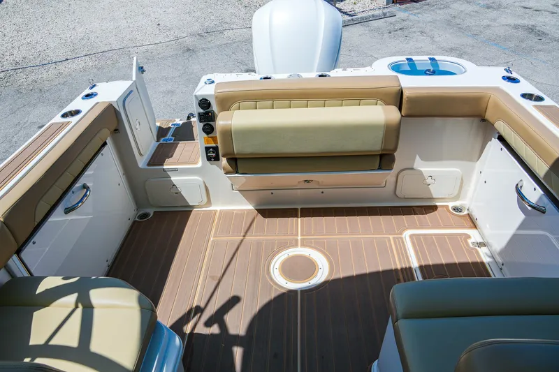 Slide: The Image of 2019 Sailfish 245 DC boat interior with tan seating and wood-patterned flooring. - 10