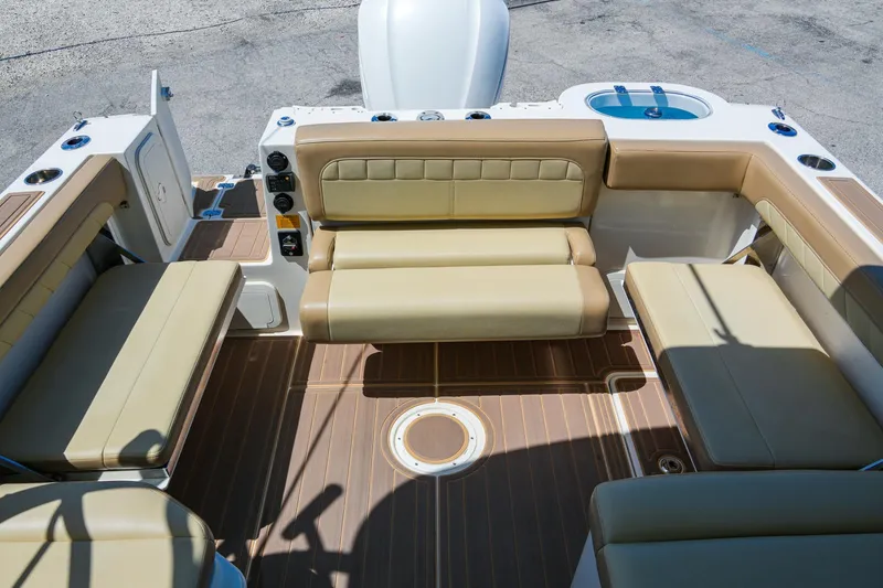 Slide: The Image of 2019 Sailfish 245 DC boat interior with beige seating and wood-style flooring. - 12