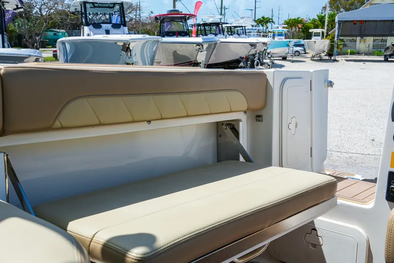 Slide: The Image of 2019 Sailfish 245 DC boat interior with beige seating, docked among other boats. - 15
