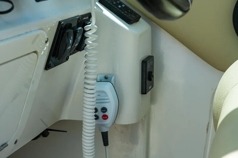Slide: The Image of Control panel of 2019 Sailfish 245 DC boat with radio handset and switches. - 22