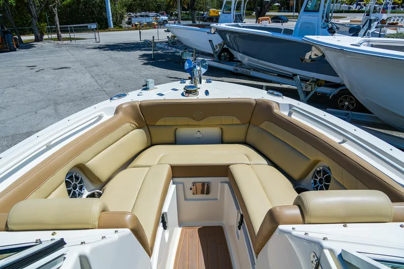Slide: The Image of 2019 Sailfish 245 DC boat with tan seating and modern design in a marina setting. - 23