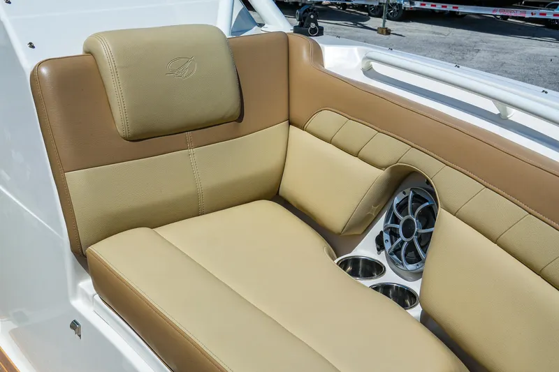 Slide: The Image of 2019 Sailfish 245 DC boat interior with tan seating, cup holders, and speaker. - 24
