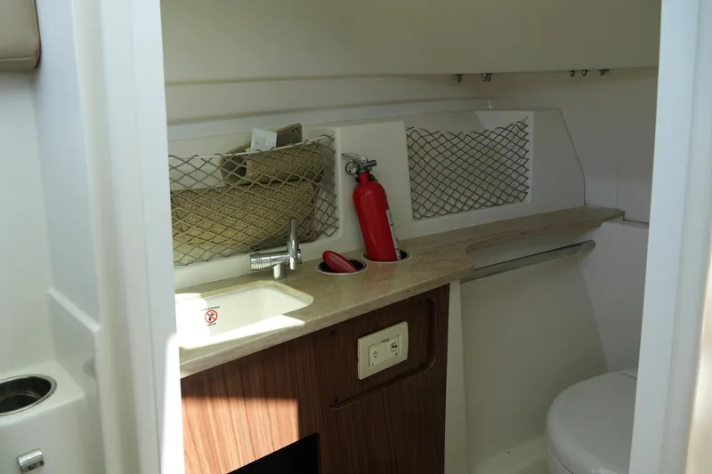 Slide: The Image of 2019 Sailfish 245 DC boat interior with sink, fire extinguisher, and storage netting. - 26