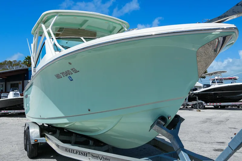 Slide: The Image of 2019 Sailfish 245 DC boat on trailer under clear blue sky. - 5