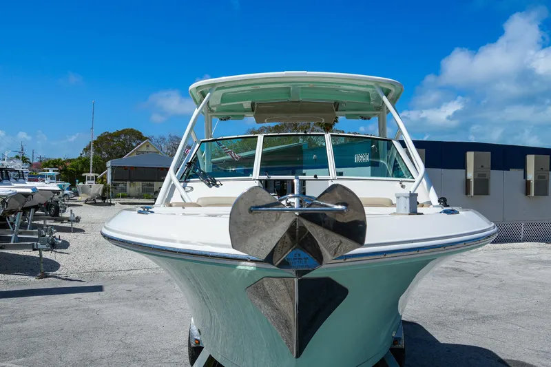Slide: The Image of 2019 Sailfish 245 DC boat on land, front view, under clear blue sky. - 6