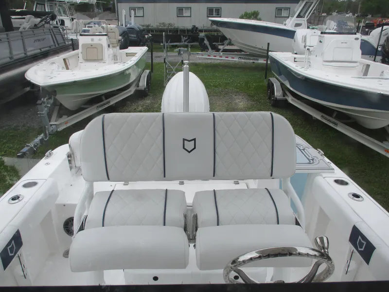 Slide: The Image of 2025 Sea Fox 228 Commander boat interior with white cushioned seating and steering wheel. - 9