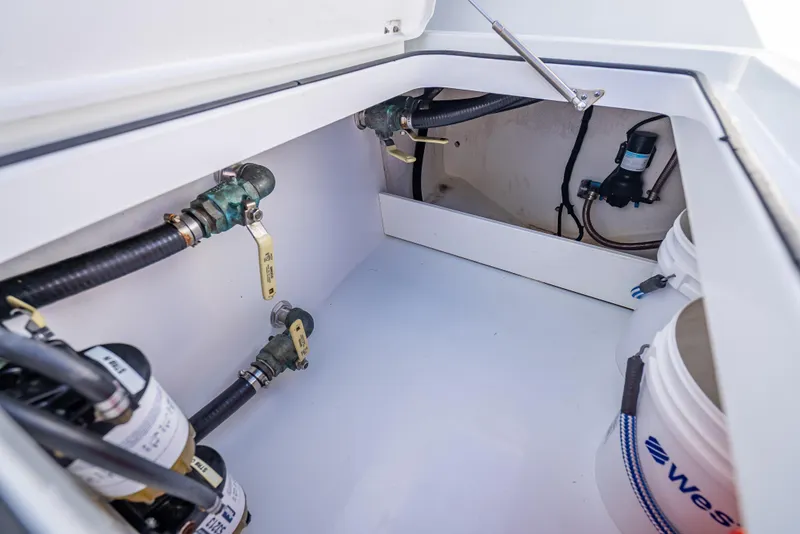 Slide: The Image of 2019 Freeman 42 LR boat compartment with hoses, valves, and storage bucket. - 37