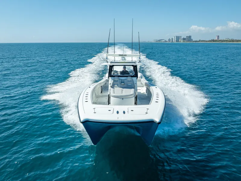 Slide: The Image of 2019 Freeman 42 LR boat cruising on open blue ocean near city skyline. - 8