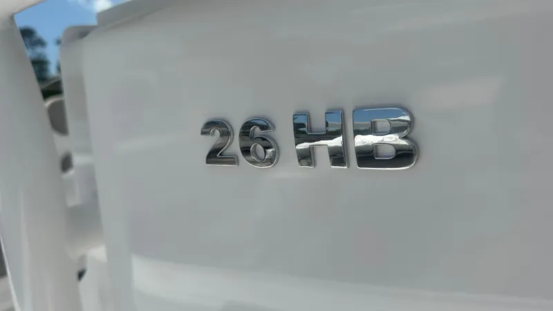 Slide: The Image of 2025 Caymas 26 HB boat emblem in shiny chrome finish. - 13