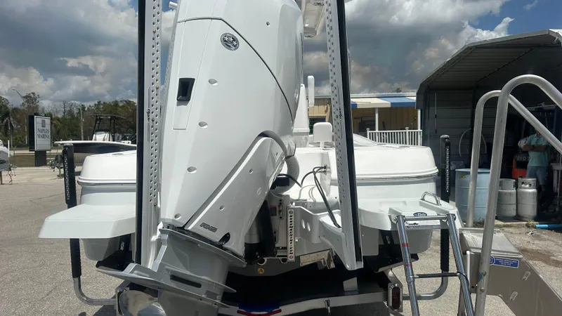 Slide: The Image of 2025 Caymas 26 HB boat with powerful outboard motor, parked outdoors under cloudy sky. - 15