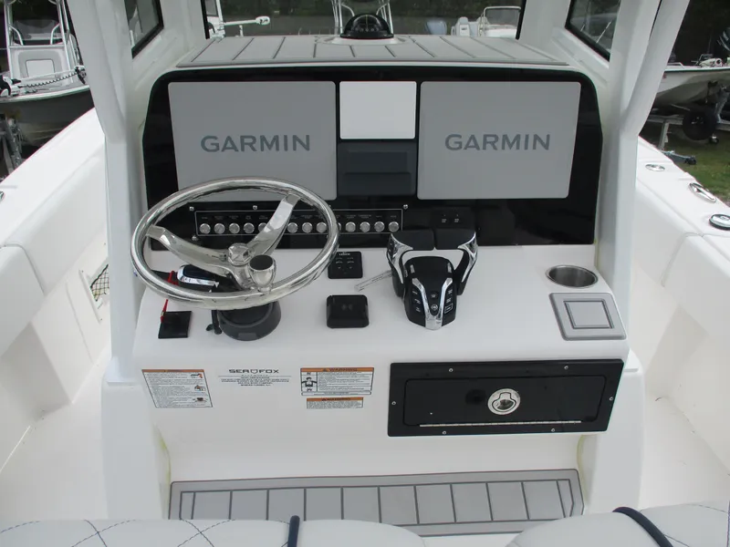 Slide: The Image of 2025 Sea Fox 282 Hybrid LT boat console with Garmin navigation systems and steering wheel. - 13