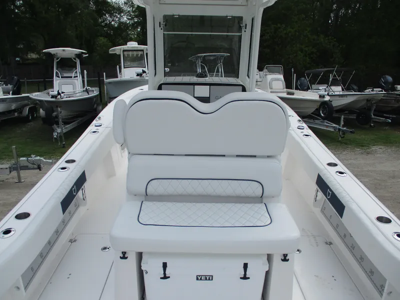 Slide: The Image of 2025 Sea Fox 282 Hybrid LT boat interior with seating and console, parked among other boats. - 9