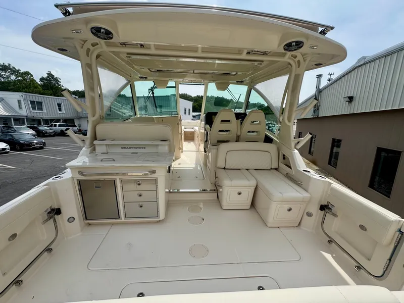 Slide: The Image of 2025 Grady-White 345 boat interior with seating and storage, docked outdoors. - 16