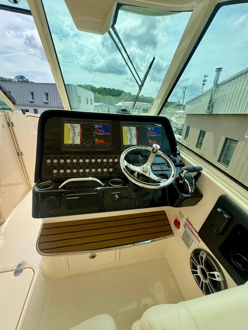 Slide: The Image of 2025 Grady-White 345 boat cockpit with advanced navigation system and steering wheel. - 8