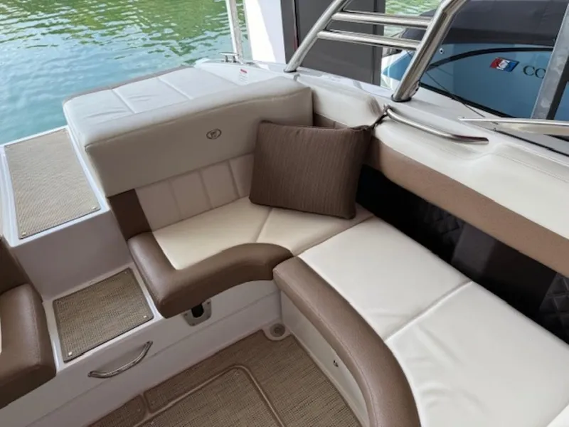 Slide: The Image of 2016 Cobalt 296 boat interior with cushioned seating and brown pillow by the water. - 11