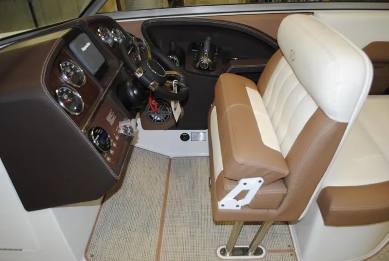 Slide: The Image of 2016 Cobalt 296 boat interior with brown and white seating and control panel. - 17
