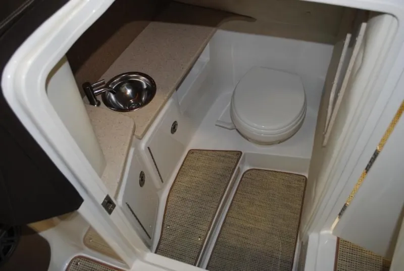 Slide: The Image of 2016 Cobalt 296 boat interior with compact bathroom, sink, and toilet. - 19