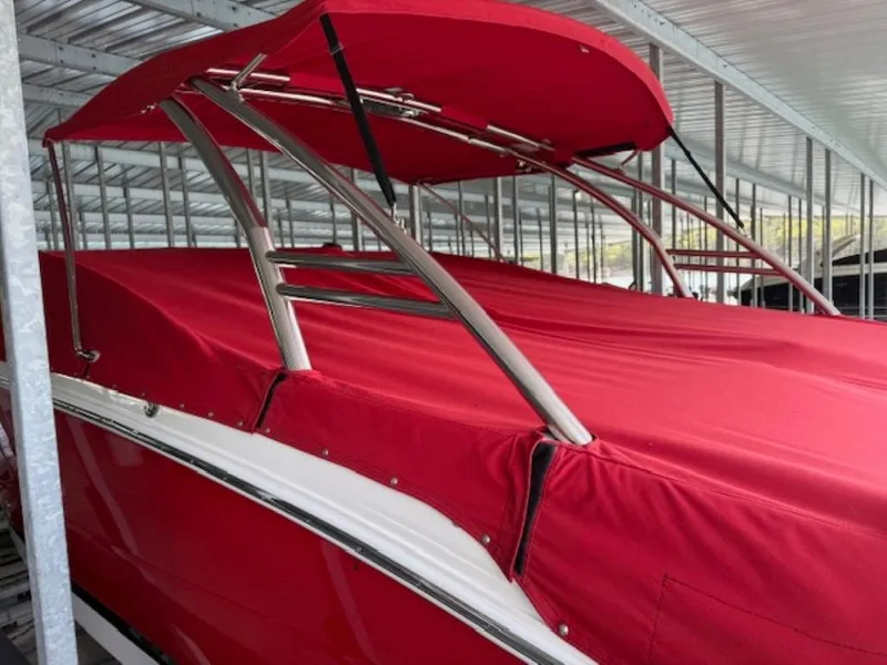 Slide: The Image of 2016 Cobalt 296 boat with red cover and canopy in a covered dock. - 2