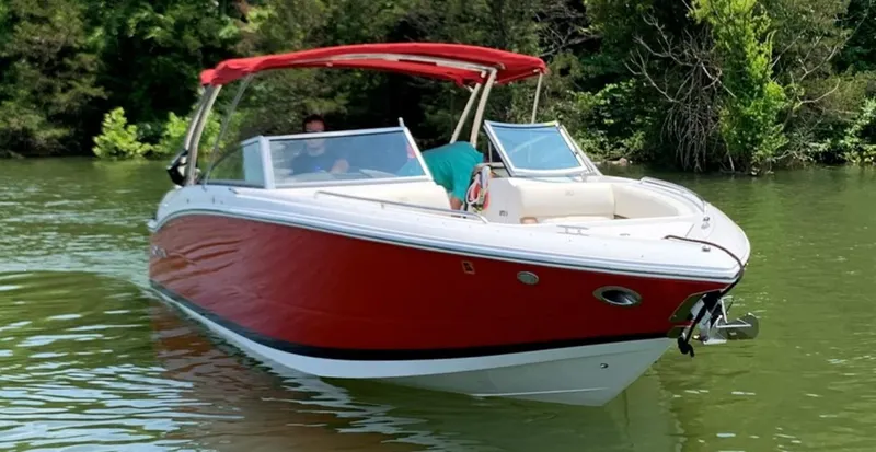 Slide: The Image of 2016 Cobalt 296 boat with red hull cruising on a calm lake. - 3