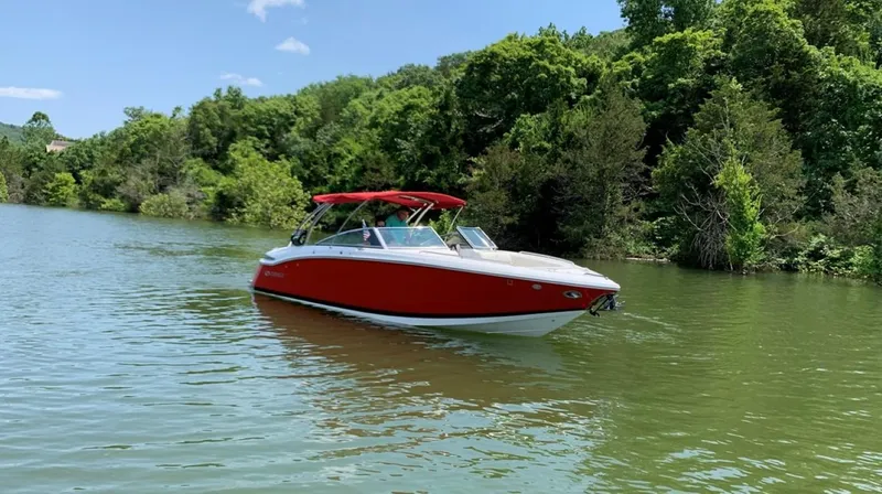 Slide: The Image of Red 2016 Cobalt 296 boat on a serene lake with lush green trees. - 4