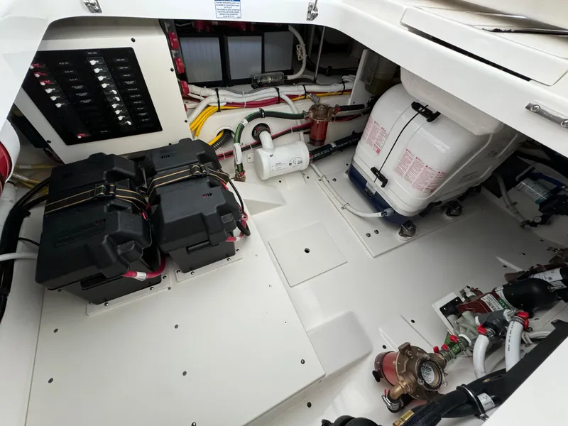 Slide: The Image of Engine compartment of 2025 Tiara Yachts 34 LS, showcasing batteries and equipment. - 12