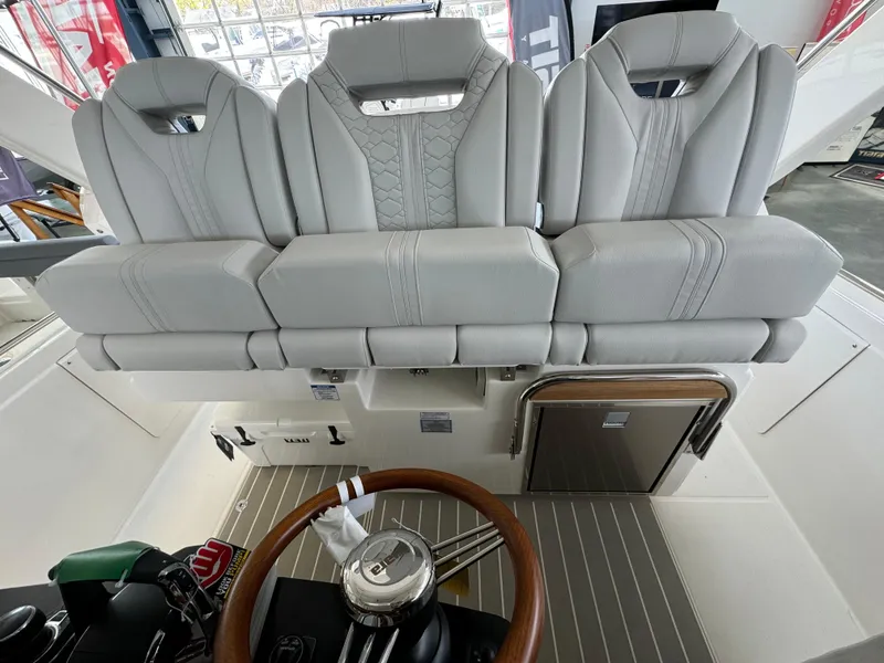 Slide: The Image of 2025 Tiara Yachts 34 LS helm with luxurious seating and modern steering wheel design. - 25