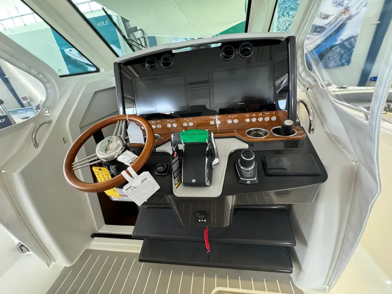 Slide: The Image of 2025 Tiara Yachts 34 LS helm with modern controls and wooden steering wheel. - 28