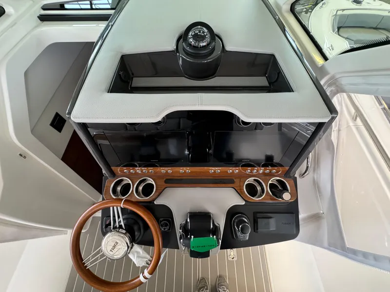 Slide: The Image of 2025 Tiara Yachts 34 LS helm with modern controls and wooden steering wheel. - 30