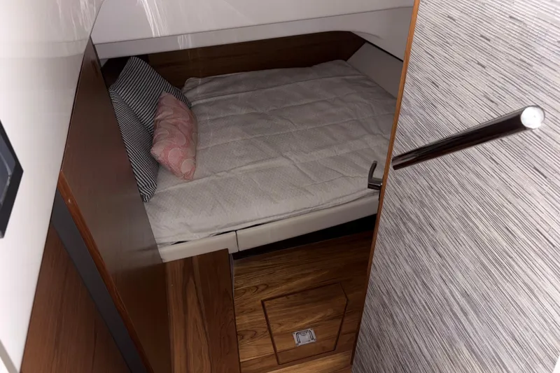 Slide: The Image of Cozy cabin interior of 2025 Tiara Yachts 34 LS with bed and wooden accents. - 34