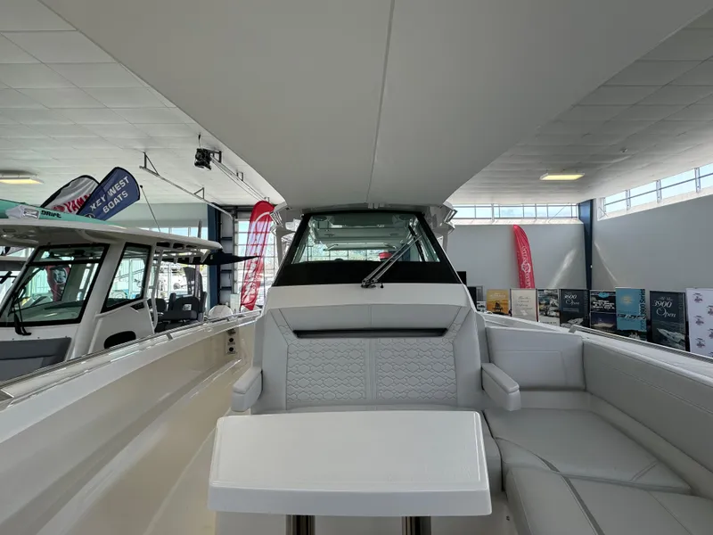Slide: The Image of 2025 Tiara Yachts 34 LS interior, showcasing sleek seating and modern design in a showroom. - 40