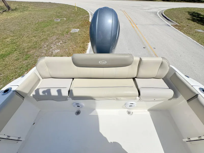 Slide: The Image of 2022 Key West 219 FS boat with cushioned seating and outboard motor on a sunny day. - 22