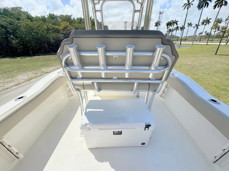 Slide: The Image of 2022 Key West 219 FS boat interior with rod holders and cooler, surrounded by palm trees. - 26