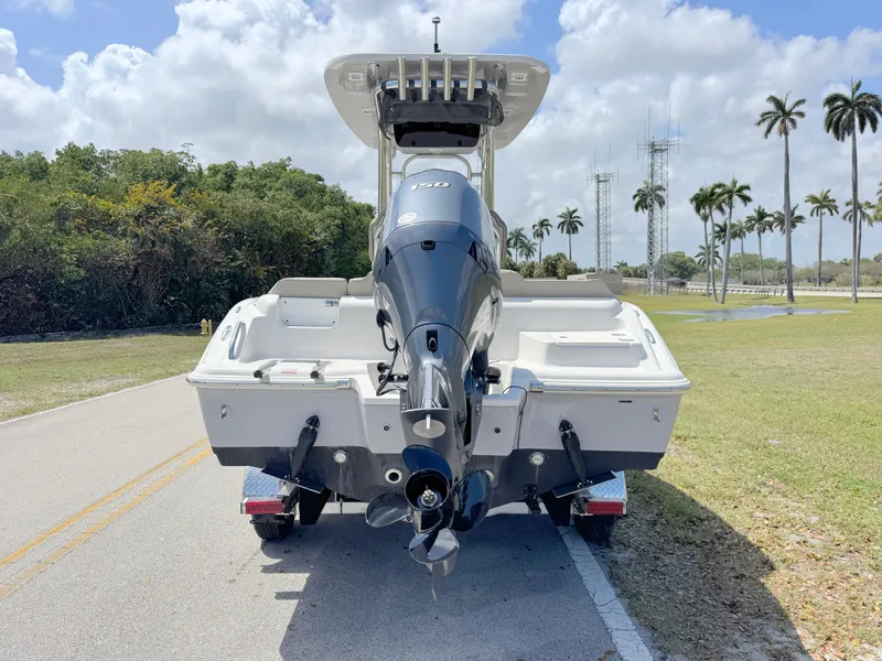 Slide: The Image of 2022 Key West 219 FS boat on trailer, parked on a sunny road with palm trees. - 3