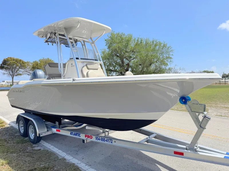 Slide: The Image of 2022 Key West 219 FS boat on trailer, parked outdoors under clear blue sky. - 6