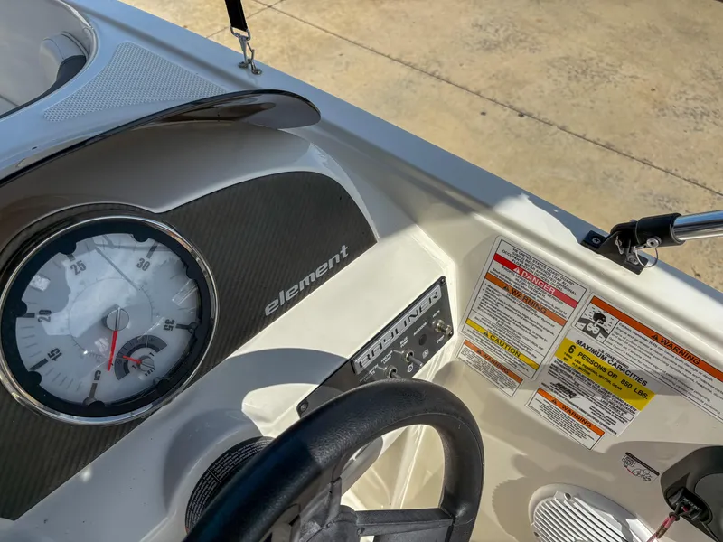 Slide: The Image of 2019 Bayliner Element E16 dashboard with speedometer and safety labels. - 11