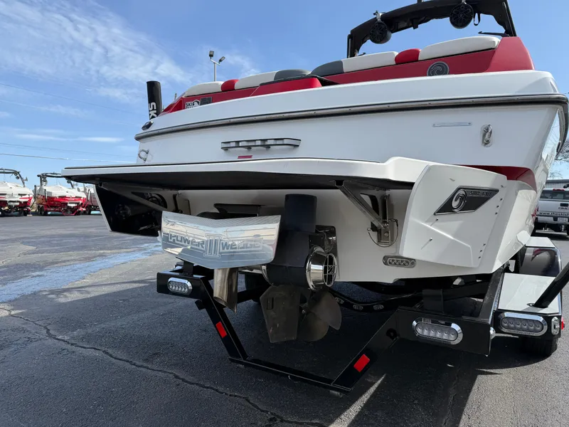 Slide: The Image of 2020 Axis A24 boat rear view with red and white seating, parked on asphalt. - 7