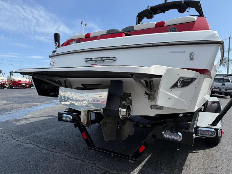 Slide: The Image of 2020 Axis A24 boat rear view with trailer, featuring red and white design. - 8