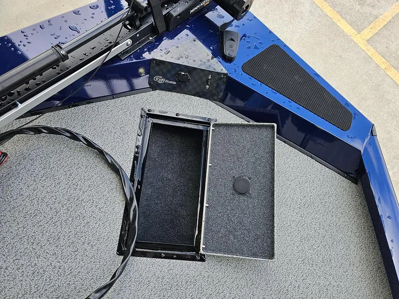 Slide: The Image of 2025 G3 Sportsman 1810 PFX boat deck with open storage compartment, wet surface. - 15