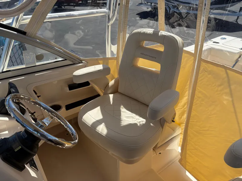 Slide: The Image of Captain's seat in 2021 Grady-White 232 Gulfstream boat, featuring a sleek steering wheel. - 10