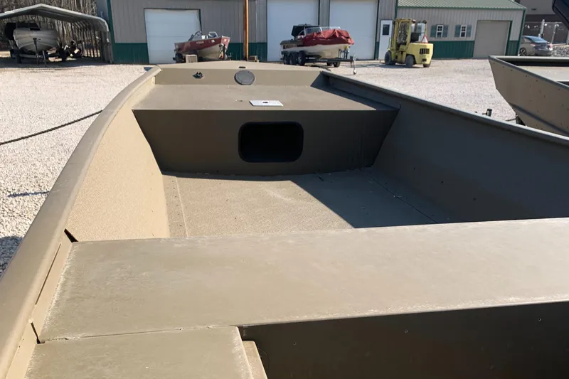 Slide: The Image of 2025 G3 1652 VBW boat, open interior view, parked outdoors near industrial buildings. - 2