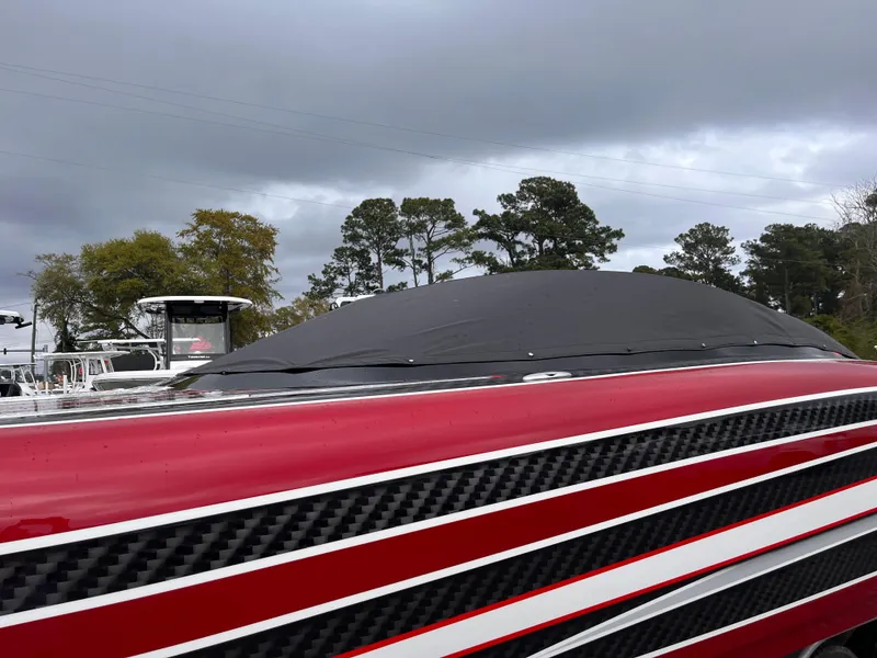Slide: The Image of Red Wright Performance 360 boat with cover, 2020 model, under cloudy sky. - 25