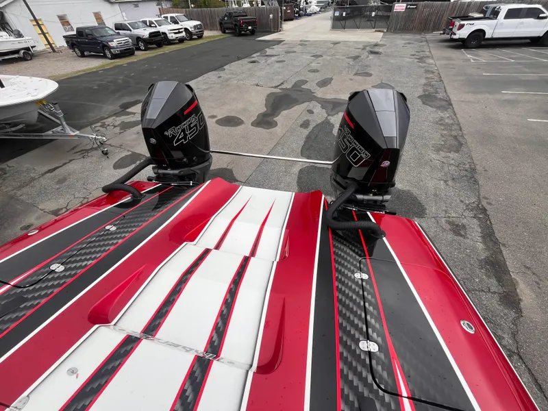 Slide: The Image of 2020 Wright Performance 360 boat with dual engines, red and black design, parked in a lot. - 8