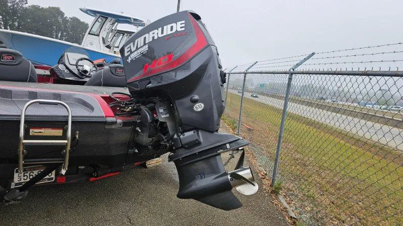 Slide: The Image of 2017 Ranger Z518 boat with Evinrude motor parked near a chain-link fence. - 8