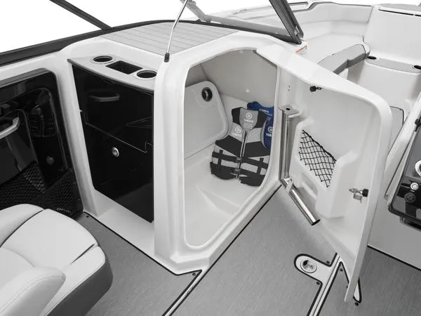 Slide: The Image of 2025 Yamaha Boats AR250 interior storage compartment with life jackets and cup holders. - 8
