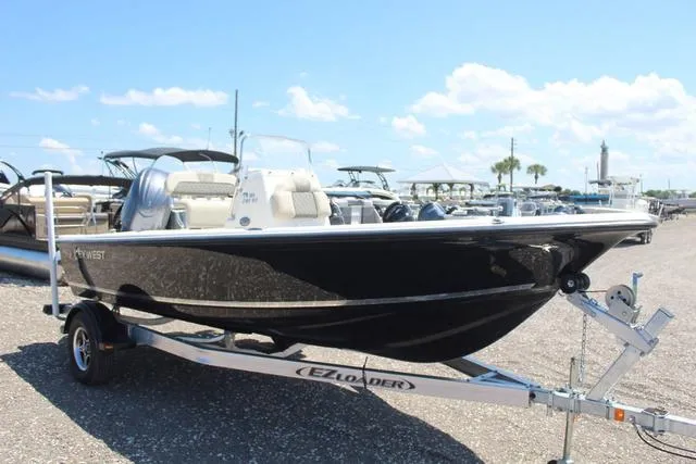 Slide: The Image of 2025 Key West 188 BR boat on trailer, parked outdoors under blue sky. - 3