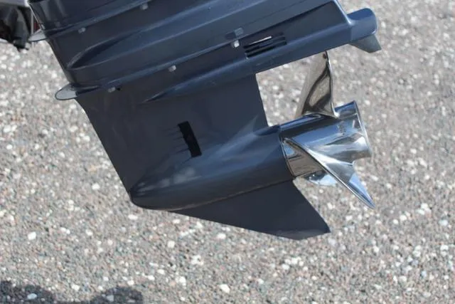 Slide: The Image of Outboard motor propeller of a 2022 Robalo R200 boat on gravel surface. - 12
