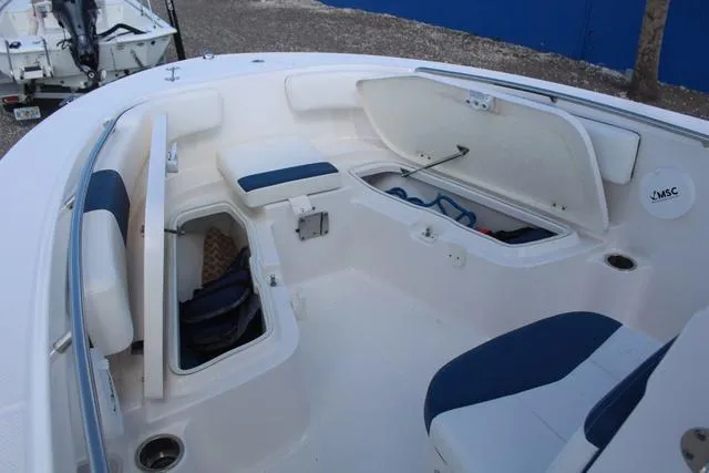 Slide: The Image of 2022 Robalo R200 boat interior with open storage compartments and blue seating. - 15