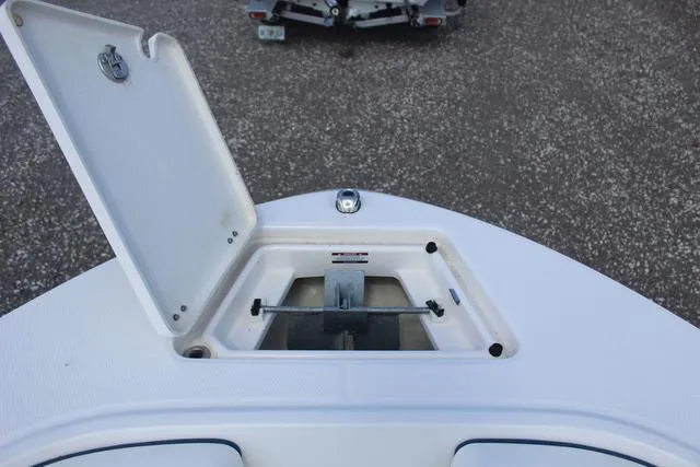 Slide: The Image of 2022 Robalo R200 boat anchor compartment with open hatch, showcasing storage space. - 16