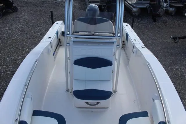 Slide: The Image of 2022 Robalo R200 boat interior with blue and white seating, center console, and spacious deck. - 17