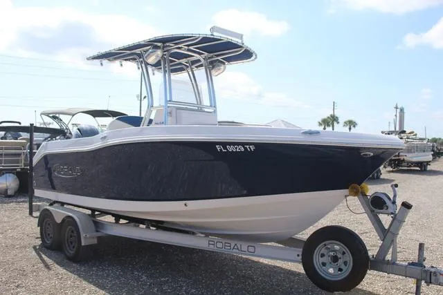Slide: The Image of 2022 Robalo R200 boat on trailer, blue and white design, parked outdoors. - 3